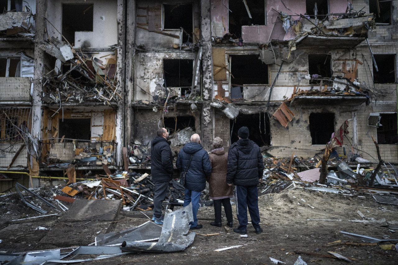 Rakétatámadás során megrongálódott lakóházat néznek emberek Kijevben 2022. február 25-én (Fotó: MTI/AP/Emilio Morenatti)