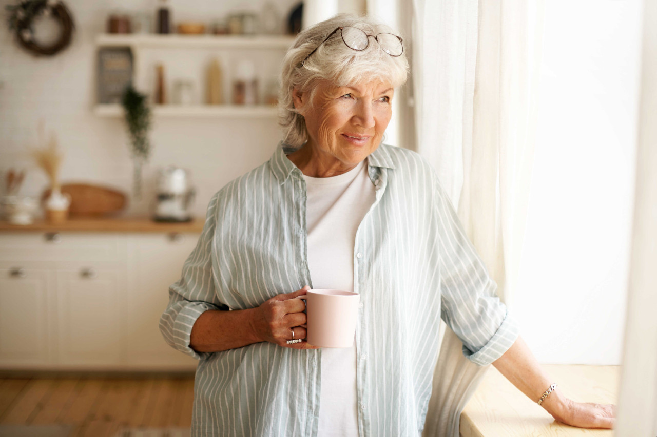 coziness-domesticity-leisure-concept-portrait-stylish-gray-haired-woman-with-round-spectacles-her-head-enjoying-morning-coffee-holding-mug-looking-outside-through-window-glass_optimized