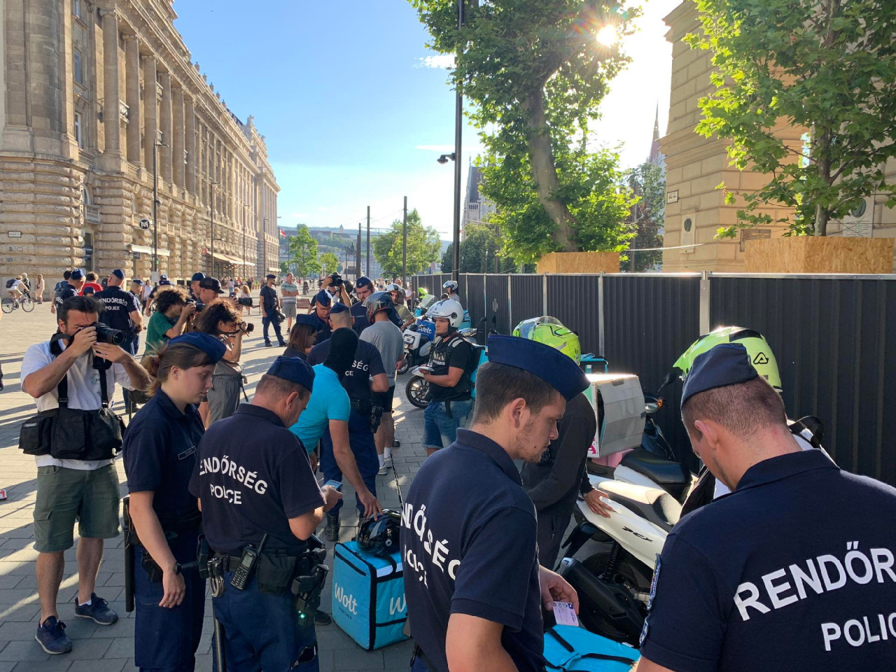 Biciklis futárokat igazoltatnak a rendőrök a Kossuth téri tüntetésen 2022. július 13-án (Fotó: Gulyás Balázs/Magyar Hang)